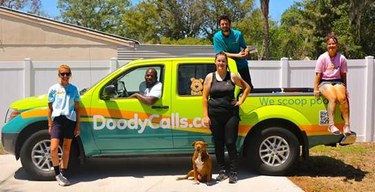 A group of people standing in front of a green truck with a dog
AI-generated content may be incorrect.